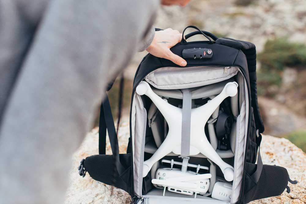 Sac à dos multimédia professionnel avec des compartiments de rangement et des sangles pour sécuriser le matériel, notamment un drone.